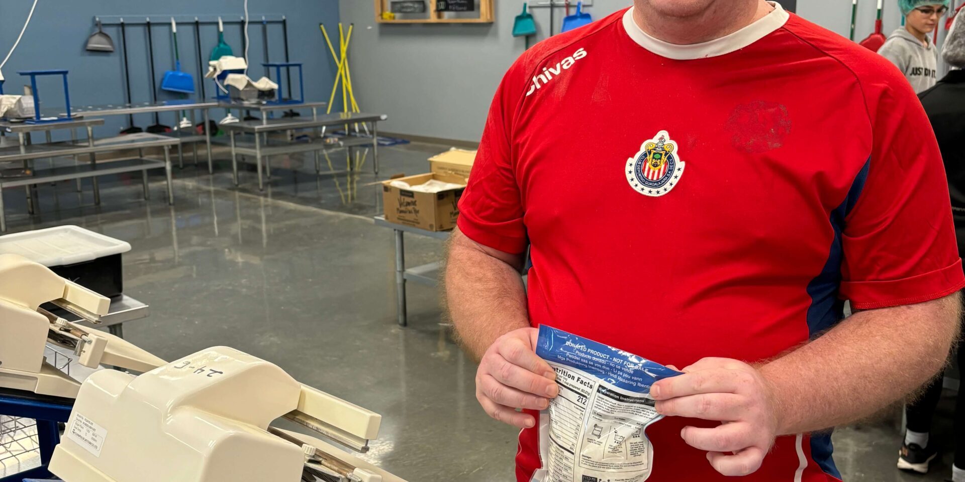 Individual volunteering by heat sealing rice meals at Feed My Starving Children
