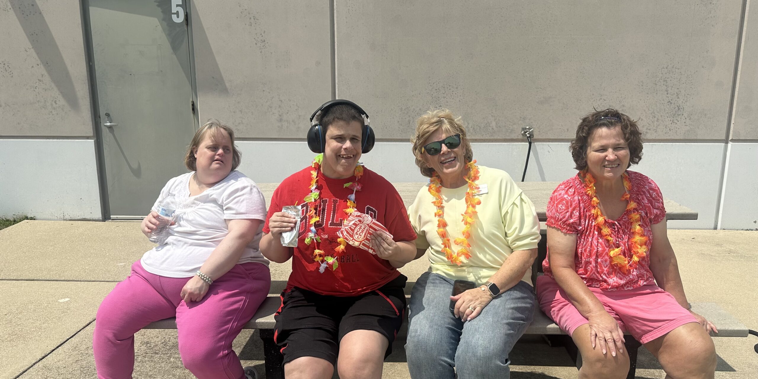 Individuals with leis posing at a summer party
