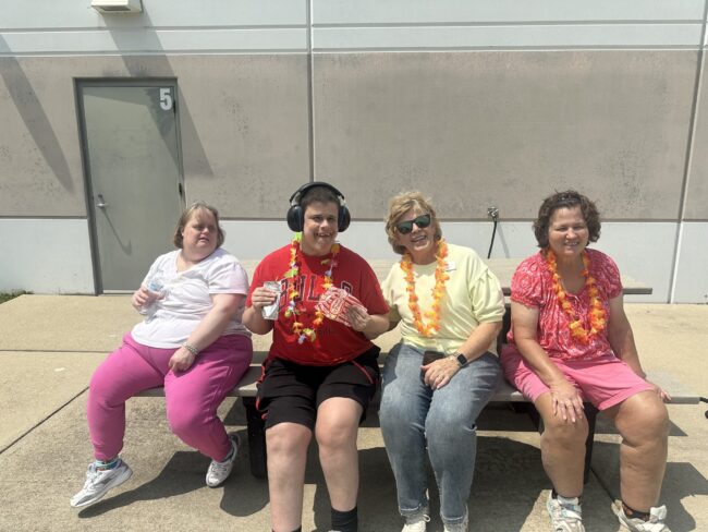 Individuals with leis posing at a summer party