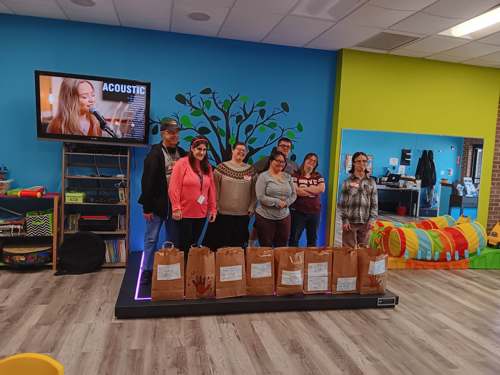 Group of individuals posing in front of paper bags